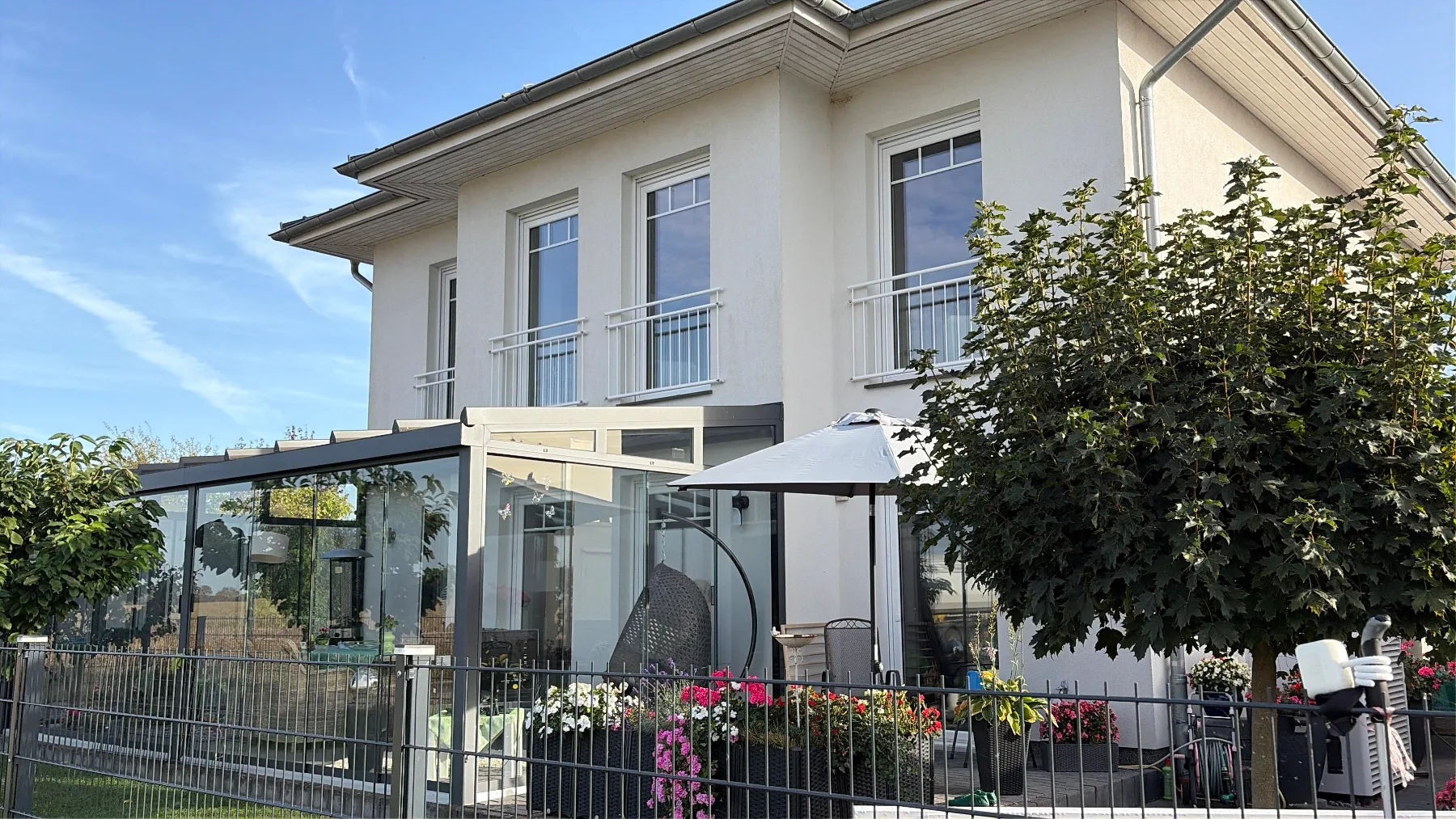Gartenseite der Stadtvilla mit Glasanbau und französischen Balkonen