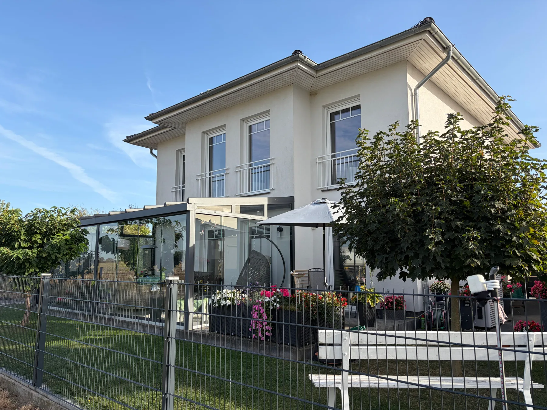 Gartenseite der Stadtvilla mit Terrasse und Glasanbau